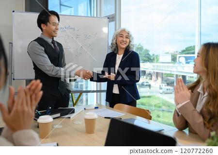 Shot of business partnership shaking hands after reaching a successful agreement during meeting 120772260