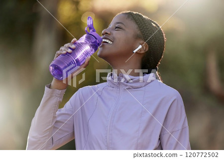 Exercise, black woman and drinking water for fitness, wellness and health outdoor to relax. Sports, young female Nigerian and athlete hydration, liquid for break and training for workout and earbuds. 120772502