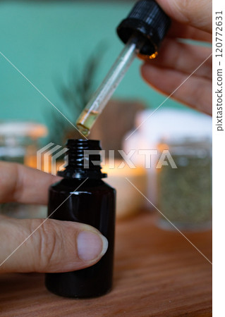 Female hand holding a dropper of essential oil..Closeup Female hand holding a dropper of essential oil..Closeup 120772631