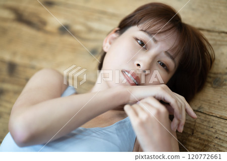 一個留著短鮑伯的年輕女子躺在地板上 120772661