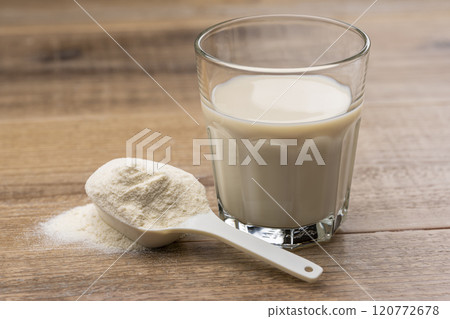 用量匙將蛋白質飲料倒入玻璃杯中 120772678