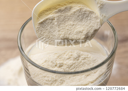 Put protein into a glass cup with a measuring spoon 120772684