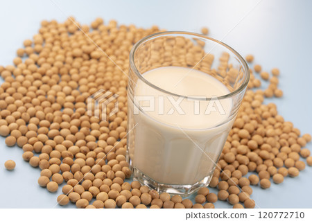Glass cup with soybeans and soy milk on a light blue background 120772710
