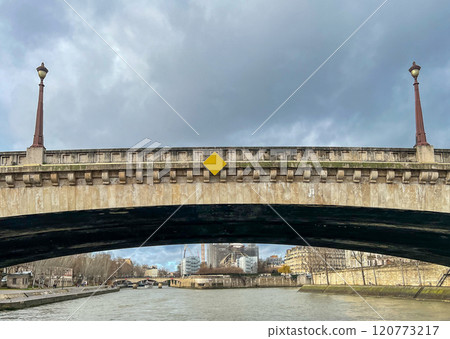 River Seine in Paris, France. Beautiful cityscape with cloudy sky with the view on the houses and bridge from a boat. River Seine in Paris, France. Beautiful cityscape with cloudy sky with the view on the houses and bridge from a boat. 120773217