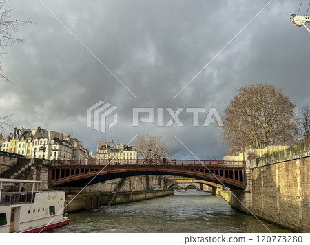 River Seine in Paris, France. Beautiful cityscape with cloudy sky with the view on the houses and bridge from a boat. 120773280