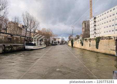 River Seine in Paris, France. Beautiful cityscape with cloudy sky with the view on the houses and bridge from a boat. 120773281