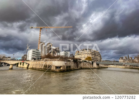River Seine in Paris, France. Beautiful cityscape with cloudy sky with the view on the houses and bridge from a boat. 120773282