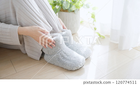 A woman with poor circulation wearing room shoes 120774511