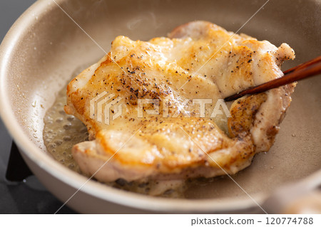 將雞腿排入煎鍋中煎炸 120774788