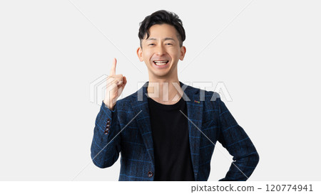 A smiling male businessman pointing with his index finger up A smiling male businessman pointing with his index finger up 120774941