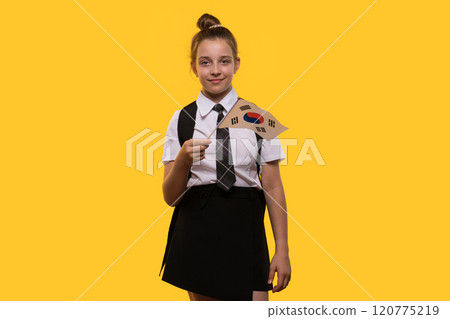 Schoolgirl holds South Korean flag while smiling confidently. 120775219