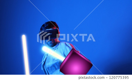 Gamer playing game while holding neon sword and wearing VR glasses. Apparatus. 120775395