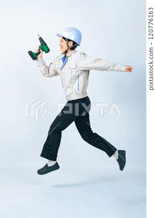 Jumping woman in helmet and work clothes, worker, engineer, full body photo Jumping woman in helmet and work clothes, worker, engineer, full body photo 120776163