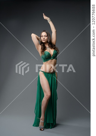 Performance by a belly dancer in a shimmering green costume showcasing grace 120776688