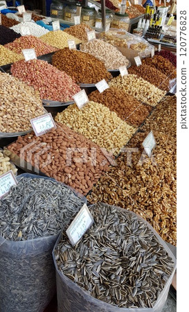 Counter of street market stall with various nuts, sunflower seeds and dried fruits in huge bags. Authentic local market of farming produce in Athens, Greece Counter of street market stall with various nuts, sunflower seeds and dried fruits in huge bags. Authentic local market of farming produce in Athens, Greece 120776828