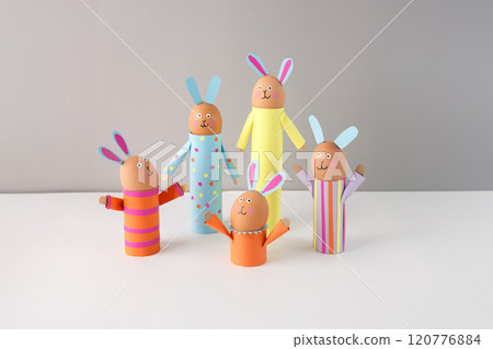 Handmade Easter bunny crafts using colored paper, eggs holder on grey background, recycled toilet paper roll or paper towel empty tube. Easter celebration and DIY craft concept. activity for kids 120776884