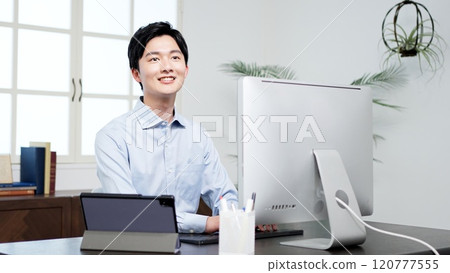 A businessman smiling while working 120777555
