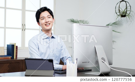 A businessman smiling while working A businessman smiling while working 120777556