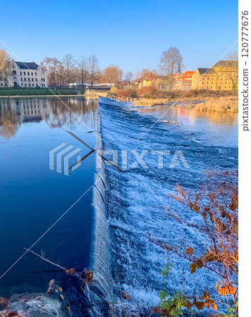 Scenic small river dam with historic buildings under a clear blue sky. High quality photo Scenic small river dam with historic buildings under a clear blue sky. High quality photo 120777676