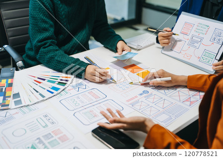 Close up view of UI developer team brainstorming on their project with laptop, smartphone and digital tablet. Close up view of UI developer team brainstorming on their project with laptop, smartphone and digital tablet. 120778521