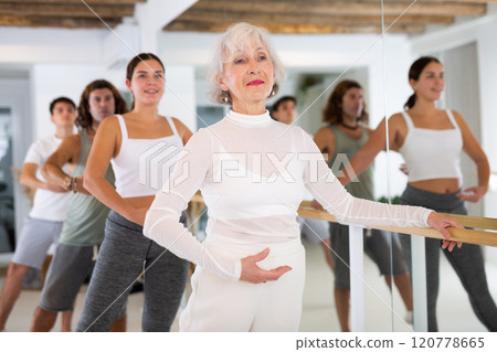 Concentrated women and men rehearsing ballet dance in dance studio 120778665