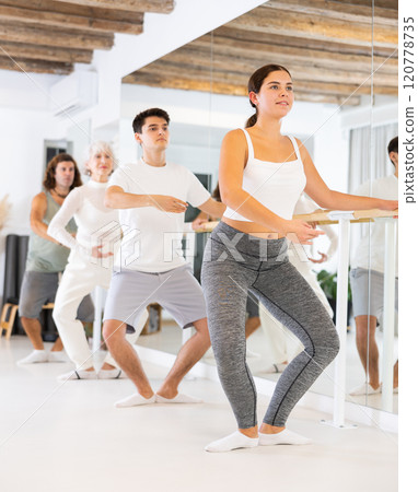 Women and men training in ballet class with other dancers in studio Women and men training in ballet class with other dancers in studio 120778735
