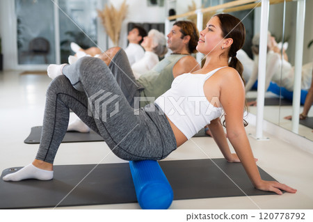 Women and men doing stretching workout during group training in yoga class Women and men doing stretching workout during group training in yoga class 120778792