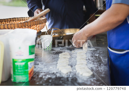 Man making soft dough of chinese doughnut stick before deep-fried. 120779748