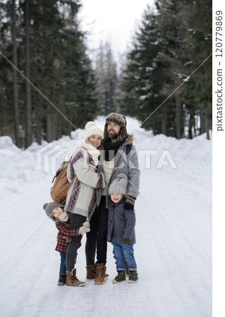 Portrait of family standing in the middle of winter snowy nature. 120779869