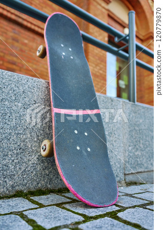 Used scratched pink skateboard against stone wall at city street. Urban sport and youth subculture concept Used scratched pink skateboard against stone wall at city street. Urban sport and youth subculture concept 120779870