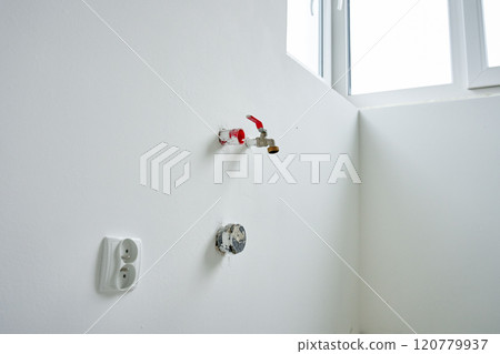 Water pipes and electrical outlets installed in new apartment during renovation 120779937