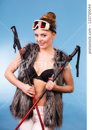 Sexy woman holding ski poles 120780044