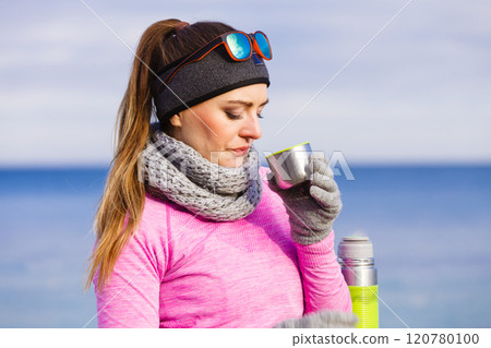 Fit woman in cold day warming up drink tea 120780100