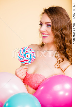 Woman holds lollipop candy and balloons Woman holds lollipop candy and balloons 120780160