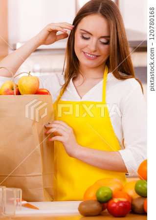 Woman housewife in kitchen with many fruits 120780168