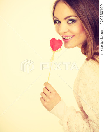Beautiful woman holding heart shaped hand stick Beautiful woman holding heart shaped hand stick 120780190