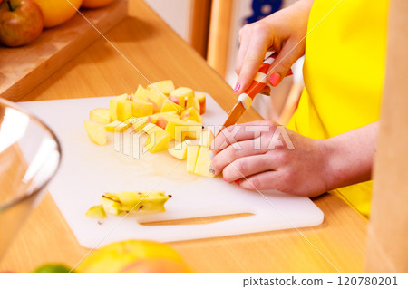 Woman housewife in kitchen cutting apple fruits 120780201