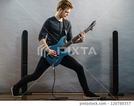 Young man playing electric guitar 120780357