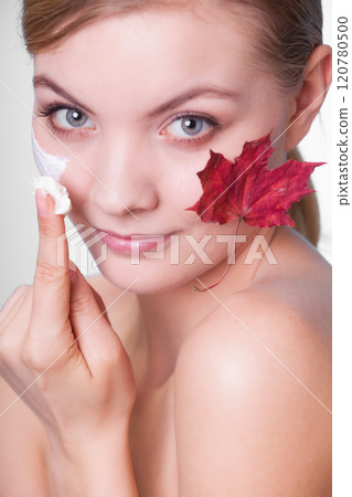 Skin care. Face of young woman girl with red maple leaf. 120780500