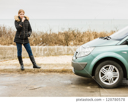 Blonde driver woman standing next to car 120780578
