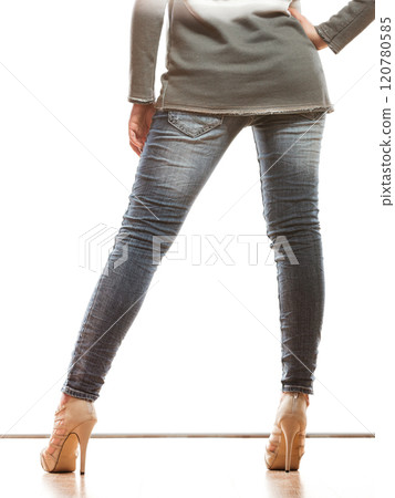 woman legs in denim trousers high heels shoes 120780585