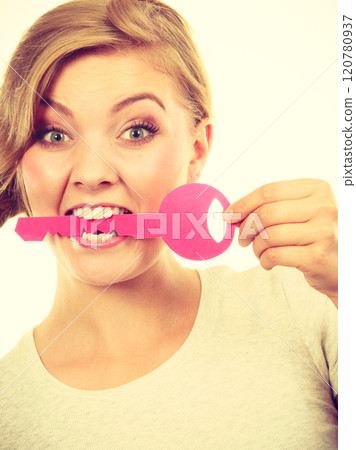 Teenage girl with braid biting key 120780937