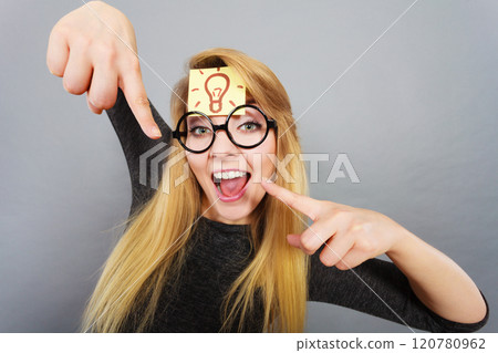 Woman having light bulb mark on forehead thinking 120780962