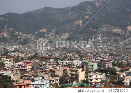 A view of the cityscape of Kathmandu, Nepal, with blue skies, mountains, fields and buildings seen from a high vantage point A view of the cityscape of Kathmandu, Nepal, with blue skies, mountains, fields and buildings seen from a high vantage point 120781054