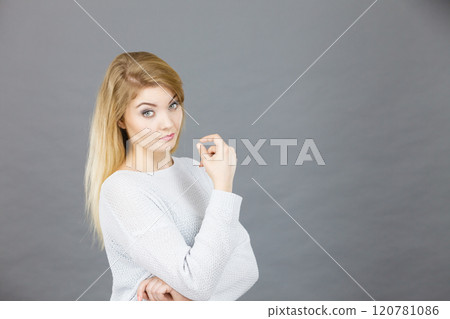 Confused young blonde woman looking annoyed 120781086