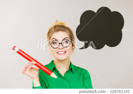 Woman holding big oversized pencil thinking 120781141