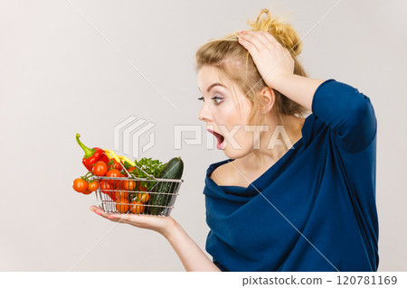 Woman with vegetables, shocked face expression 120781169