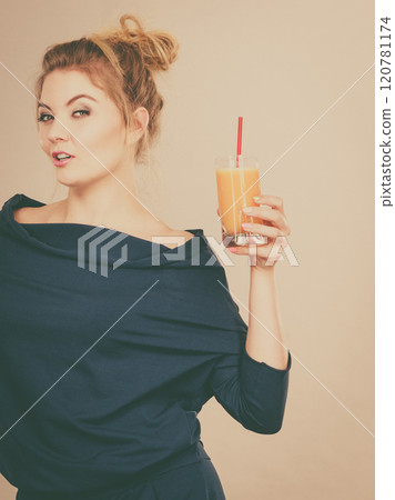 Happy woman holding fresh orange juice Happy woman holding fresh orange juice 120781174