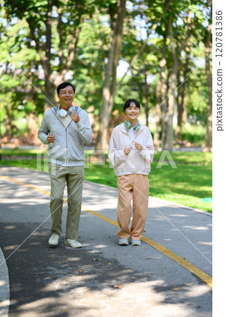 Happy senior man and his adult daughter jogging together in a beautiful park 120781386