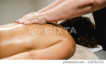 Masseur massaging woman back with essential oils in spa center 120781519